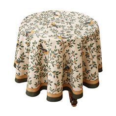 a round table covered in a white and green floral print with birds sitting on the tree branches