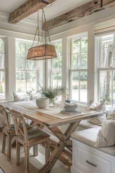 a dining room table and bench with windows in the background