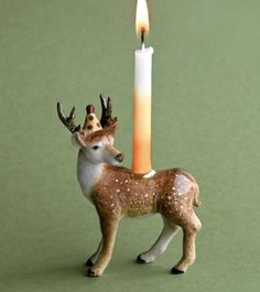 a small deer figurine with a candle in the shape of a crown on its head