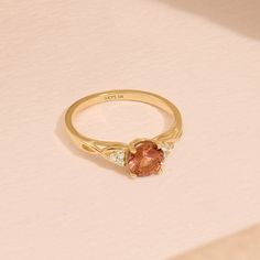 Crafted in 14k Solid Gold, our Braided Padparadscha Engagement Ring is a vintage-inspired masterpiece. The captivating Oranged-hued gemstone, intricately braided band, and delicate accents create a unique and elegant piece. Whether for an engagement or an anniversary, this ring symbolizes enduring love and timeless beauty. Make her heart skip a beat with this exquisite ring that's as extraordinary as she is. Ring Details * Gold Kt: 10k 14k 18k Solid Gold * Band Options; Yellow Gold, White Gold, Rose Gold * Band Width: 1.60 mm * Top Width: 6.00 mm * Thickness: 1.40 mm * Gemstone: Lab Created Padparadscha - Round 6mm * Gemstone: Diamond * Gem Color and Clarity: G Colour SI Clarity * Diamond CTW: 0.12ctw  🦄 Find out more about my shop at: https://etsy.me/3uTPmyQ 💅 Go Directly to My Sections Gold Round Engagement Ring, Padparadscha Sapphire Ring, Pink Gemstone Ring, Round Engagement Ring, Ring Crystal, Padparadscha Sapphire, Solid Gold Band, Round Engagement Rings, Engagement Ring Shapes