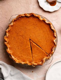 a pie sitting on top of a table next to plates and utensils in front of it