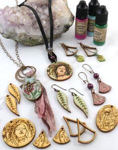 a collection of jewelry sitting on top of a table next to some rocks and bottles