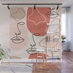 an abstract wall mural with pink, orange and white faces on it's side