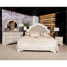 a white bed sitting in a bedroom next to a dresser