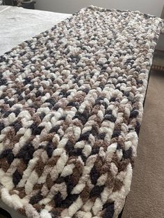 a bed with a white and brown blanket on top of it