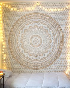 a bed with lights around it and a large tapestry hanging on the wall behind it