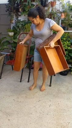 a woman holding two pieces of furniture in her hands