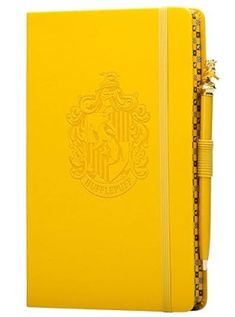 a yellow harry potter notebook with the hogwarts crest on it's cover