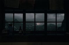 a window with some books on it and mountains in the background