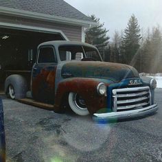 an old truck parked in front of a garage