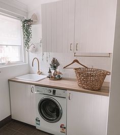 a laundry room with a washer and dryer next to a window in the corner