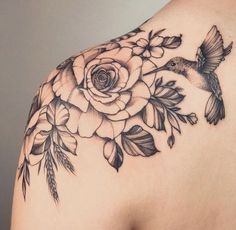 the back of a woman's shoulder with flowers and a hummingbird on it