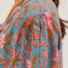 Add a touch of bohemian flair to your wardrobe with the Aqua Pink Bohemian Tunic. Made from 100% viscose, this tunic provides excellent comfort and breathability for all-day wear. The eye-catching aqua and pink floral pattern brings a vibrant and cheerful look to any outfit. Featuring 3/4 sleeves, this tunic offers a relaxed yet polished style. The inner lace detail on the placket adds a feminine and elegant touch, while the half placket with shell buttons provides a stylish finish. Designed to Bohemian Tunic Blouse In Viscose, Bohemian Viscose Tunic Blouse, Boho Print Rayon Blouse For Beach, Boho Print Rayon Blouse For The Beach, Flowy Bohemian Blouse With Vibrant Print, Bohemian Turquoise Blouse For The Beach, Bohemian Viscose Tunic Top, Bohemian Turquoise Tops For Summer, Bohemian Viscose Blouse For Vacation