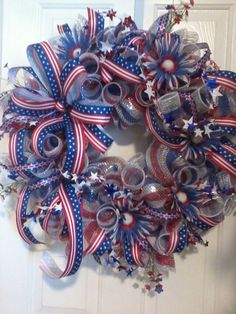 a patriotic wreath with red, white and blue ribbons