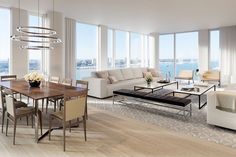 a living room filled with lots of furniture and large windows overlooking the cityscape