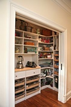 an open pantry with lots of items on the shelves and in front of it is a phone