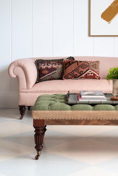 a pink couch sitting next to a green ottoman on top of a checkered floor