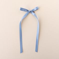 a blue ribbon tied to the side of a white wall with a bow on it