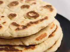 a stack of pita bread on a black plate