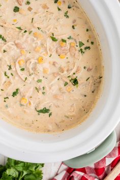 a white bowl filled with soup and garnished with parsley