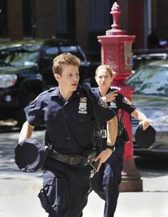 two police officers are walking down the street