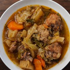 a white bowl filled with meat and vegetables