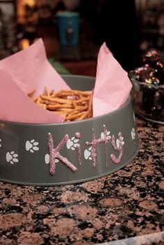 a dog's food bowl with the word kitty written on it and paw prints