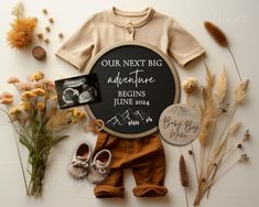 a baby's birth announcement surrounded by flowers, shoes and other items on a white surface