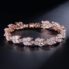 A classy bracelet for the modern bride! Featuring faceted cubic zirconia that catch the light from every angle, the bracelet is rhodium / 14K rose gold / 14K yellow gold plated for a flawless finish which perfectly enhances the intricate detailing and conveys a modern take on old elegance. The bracelet measures 0.5" wide (approx. 15mm) and 7" long (approx. 18cm). Closure is a secure fold-over clasp. Choose between Silver, Rose Gold and Yellow Gold finishes. To make your choice, select from the d Trollbeads Bracelet, Crystal Earrings Wedding, Bridal Earrings Drop, Cz Bracelet, Bride Earrings, Crystal Bangle, Leaf Jewelry, Bridal Bracelet, Zirconia Earrings