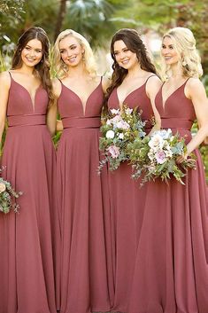 the bridesmaids are all dressed in maroon dresses and bouquets for their wedding