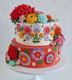 a multi - tiered cake decorated with colorful flowers