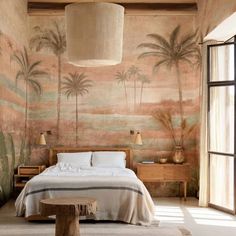 a bedroom with palm trees painted on the wall and bed in front of large window