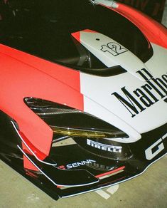 a red and white sports car parked in a garage