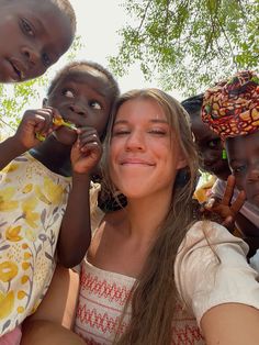 a group of young women standing next to each other holding something in their hands and smiling at the camera