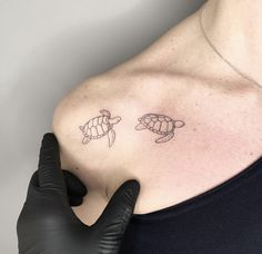 a woman's shoulder with two small turtles on the left side of her arm