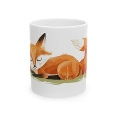 a white coffee mug with an orange fox on it