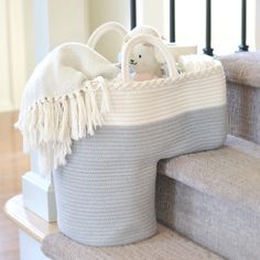 a basket with a stuffed animal in it sitting on some stairs