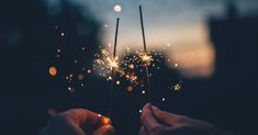 two people holding sparklers in their hands