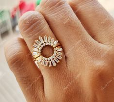 a woman's hand with a gold ring on top of her finger and an open diamond