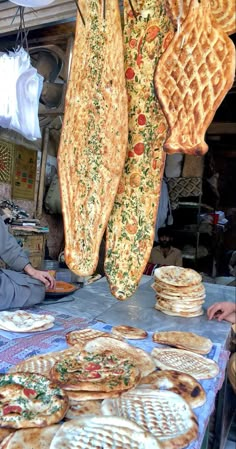 a man sitting at a table with many different types of waffles on it