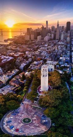 an aerial view of a large city with tall buildings and lots of trees in the foreground