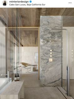 a bathroom with marble walls and flooring next to a bathtub in the middle