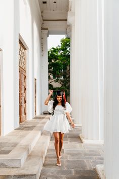 a woman in a white dress standing on some steps