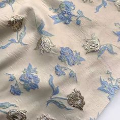 the fabric has blue and silver flowers on it