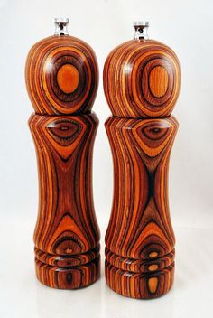 two wooden salt and pepper shakers on a white surface with an orange circle in the center