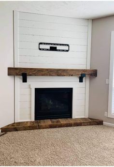 an empty living room with a fireplace and white walls