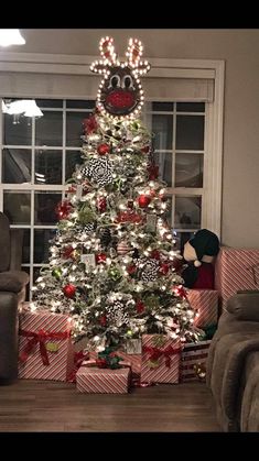 a decorated christmas tree in front of a window