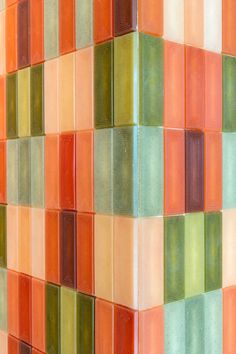 an orange and green tiled wall with different colors