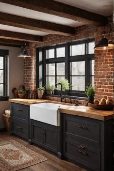 a kitchen with black cabinets and white sink in front of two windows that look out onto the street