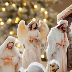 the nativity scene features figurines of jesus, mary and baby jesus in front of a christmas tree